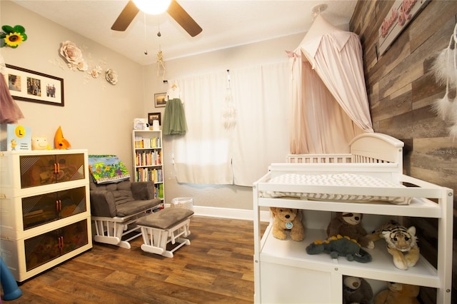 bedroom featuring dark hardwood / wood-style floors, wood walls, and ceiling fan