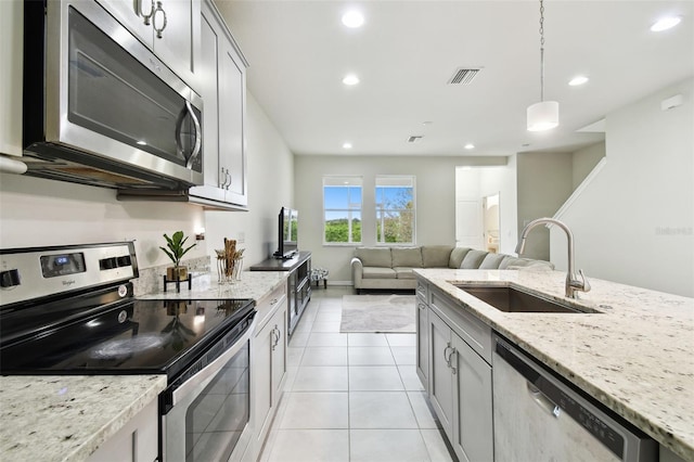 kitchen with sink, hanging light fixtures, appliances with stainless steel finishes, and gray cabinets