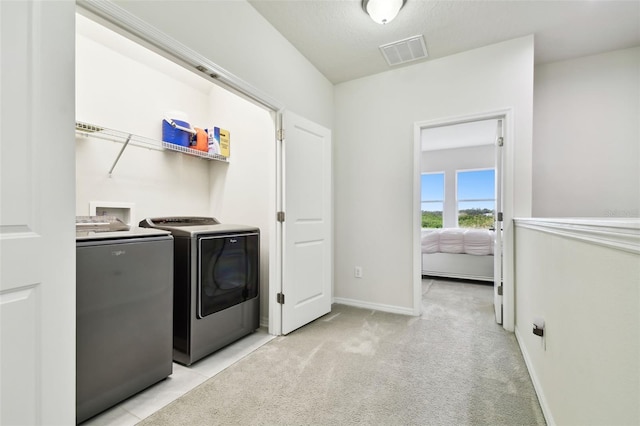 laundry area with light colored carpet and washer and clothes dryer