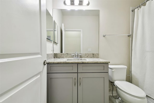 bathroom with curtained shower, toilet, and vanity