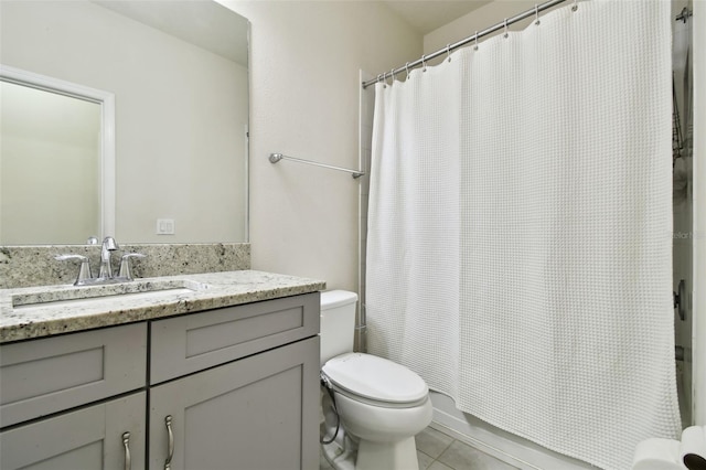 bathroom with tile patterned floors, toilet, vanity, and walk in shower