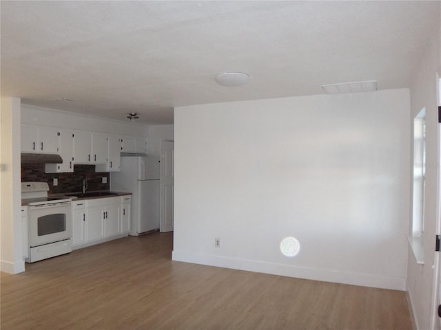 kitchen with decorative backsplash, light wood-type flooring, white appliances, sink, and white cabinetry