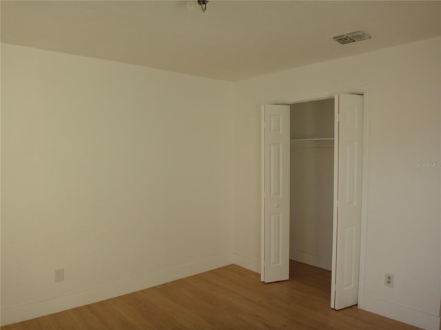 unfurnished bedroom with a closet and light hardwood / wood-style flooring