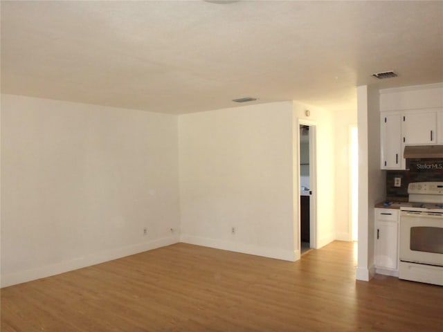 kitchen featuring light hardwood / wood-style floors, white cabinetry, white electric range, and backsplash