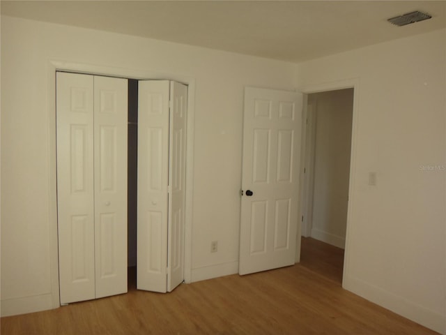 unfurnished bedroom with light hardwood / wood-style floors and a closet