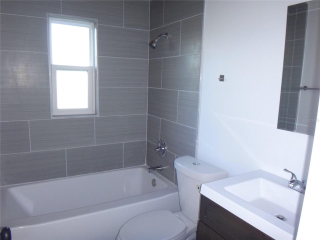 full bathroom with toilet, vanity, and tiled shower / bath