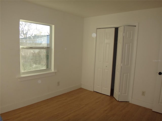 unfurnished bedroom featuring a closet and hardwood / wood-style floors