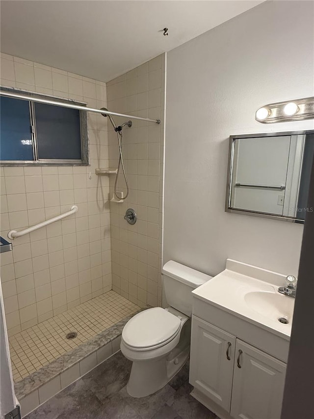 bathroom featuring tiled shower, vanity, and toilet