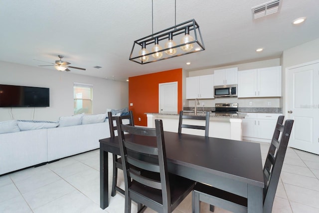 dining room featuring a textured ceiling, ceiling fan, light tile patterned floors, and sink