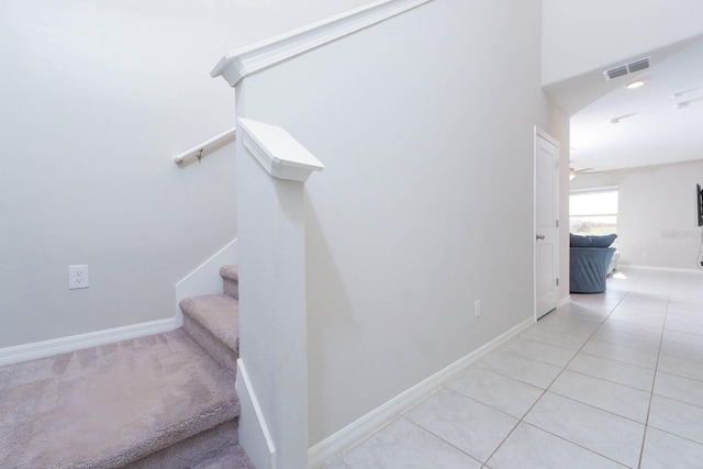 stairway featuring ceiling fan and tile patterned floors