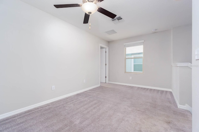 spare room with ceiling fan and light carpet