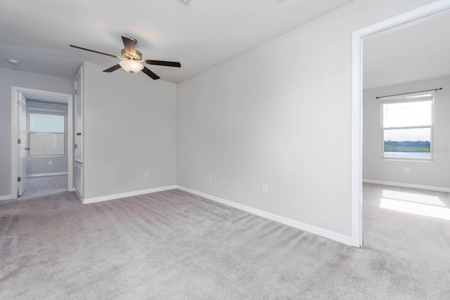 spare room with ceiling fan and light carpet