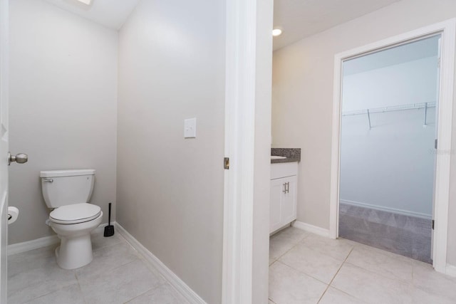 bathroom featuring toilet, tile patterned flooring, and vanity