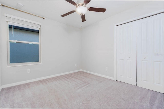 unfurnished bedroom with light carpet, a closet, and ceiling fan