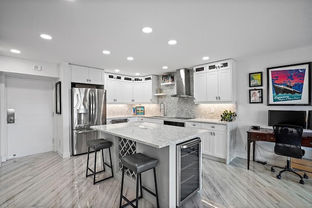 kitchen with stainless steel refrigerator with ice dispenser, wall chimney exhaust hood, a kitchen island, white cabinetry, and beverage cooler