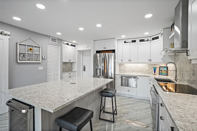 kitchen with a center island, white cabinets, wine cooler, a kitchen bar, and stainless steel fridge with ice dispenser