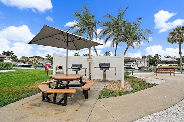 view of property's community with a water view, a yard, and a swimming pool