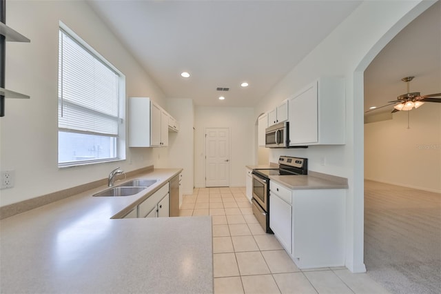 kitchen with white cabinets, light tile patterned floors, stainless steel appliances, and sink