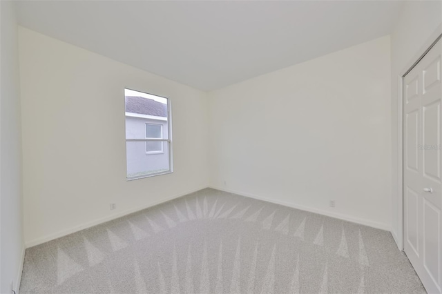 spare room featuring light colored carpet