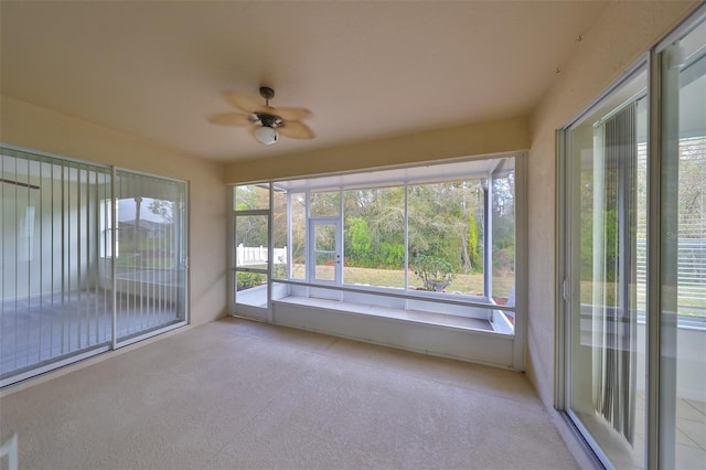 unfurnished sunroom with ceiling fan