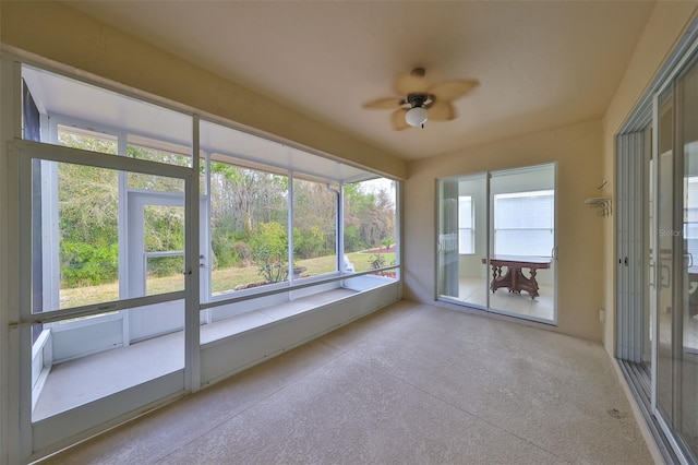 unfurnished sunroom featuring ceiling fan