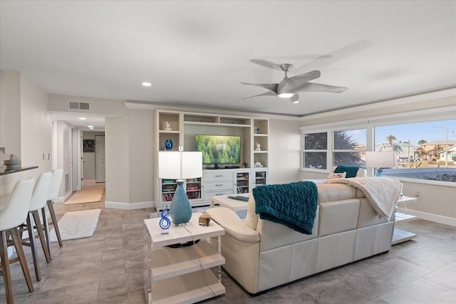 living room with ceiling fan and crown molding