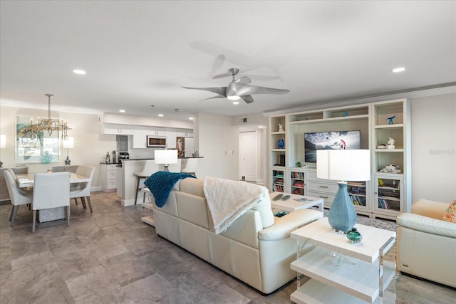 living room with ceiling fan with notable chandelier