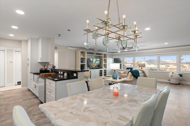 dining space featuring sink and an inviting chandelier