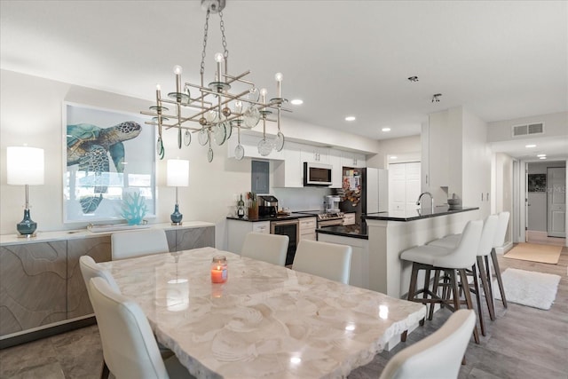 dining space featuring sink, beverage cooler, and an inviting chandelier