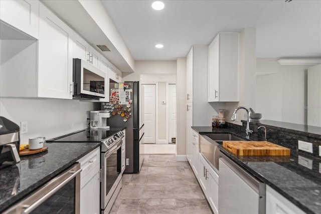 kitchen with white cabinets, wine cooler, appliances with stainless steel finishes, and dark stone counters