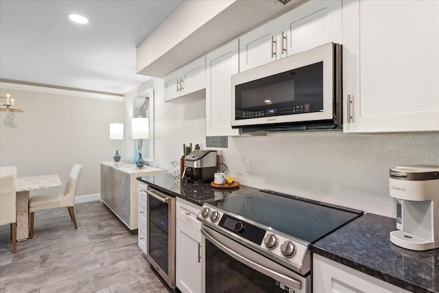 kitchen featuring dark stone countertops, white cabinetry, stainless steel appliances, and wine cooler