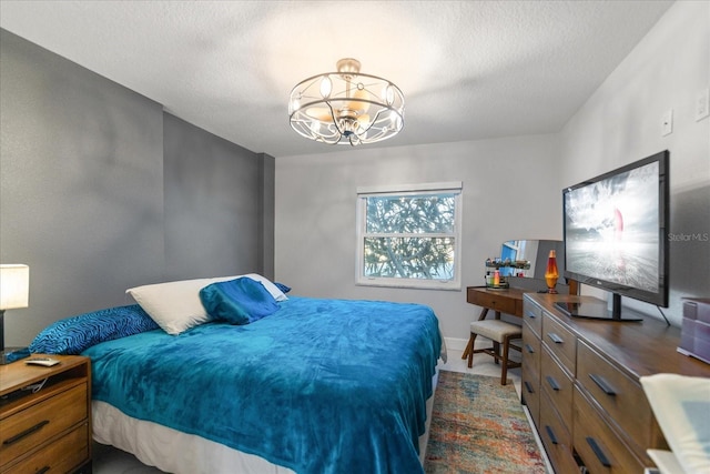 bedroom featuring a textured ceiling and an inviting chandelier