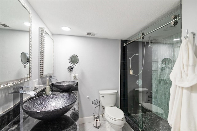 bathroom featuring sink, a shower with door, a textured ceiling, and toilet