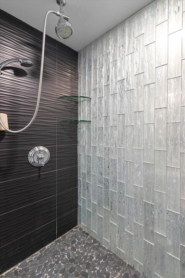 bathroom featuring a textured ceiling and tiled shower