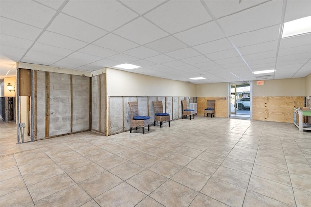 basement with a drop ceiling and light tile patterned floors