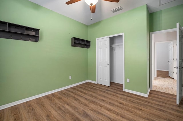 unfurnished bedroom featuring ceiling fan, dark wood-type flooring, and a closet