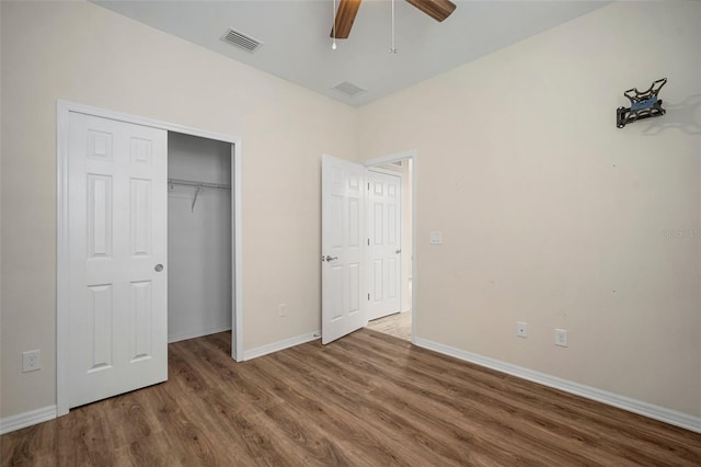 unfurnished bedroom featuring ceiling fan, wood-type flooring, and a closet