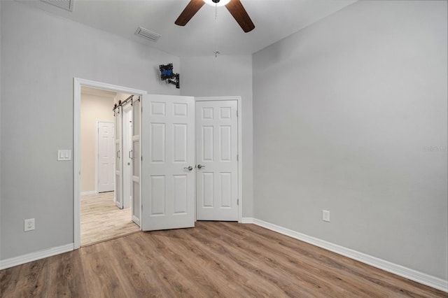 unfurnished bedroom featuring ceiling fan, a closet, and light hardwood / wood-style floors