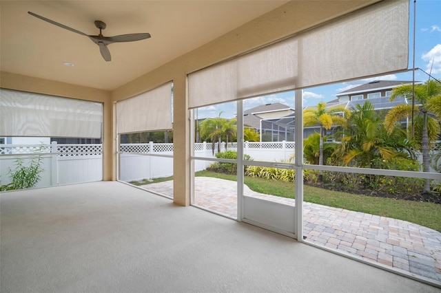 unfurnished sunroom with ceiling fan