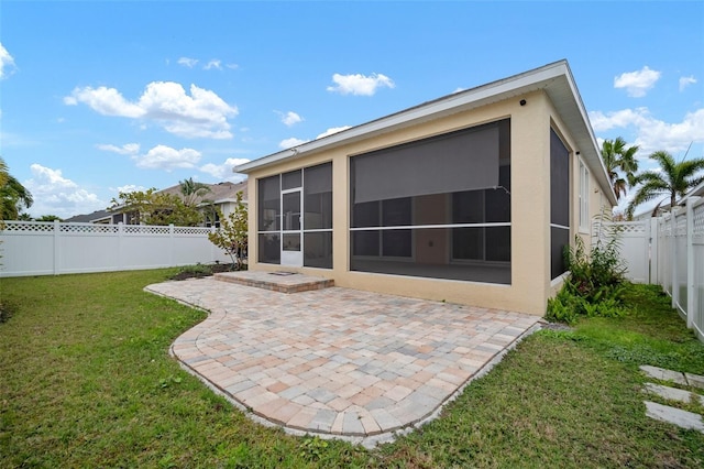 rear view of house featuring a patio area, a yard, and a sunroom