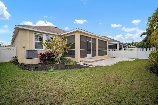 rear view of house with central air condition unit, a sunroom, a yard, and a patio