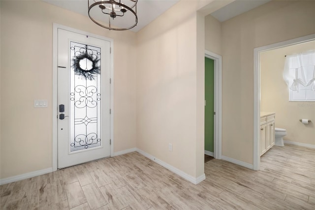 entryway with light hardwood / wood-style flooring and a notable chandelier