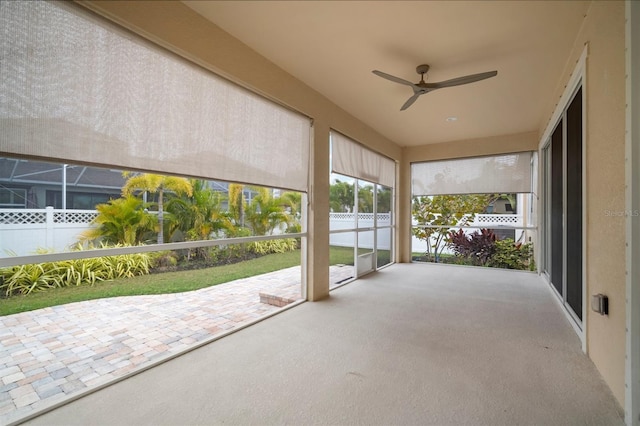 unfurnished sunroom with ceiling fan