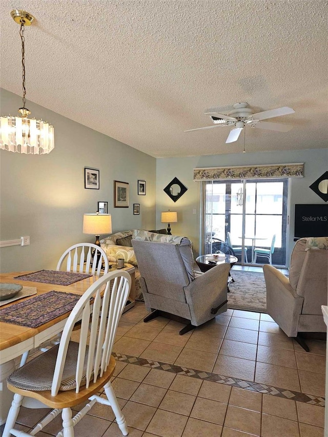 tiled living room with ceiling fan with notable chandelier and a textured ceiling