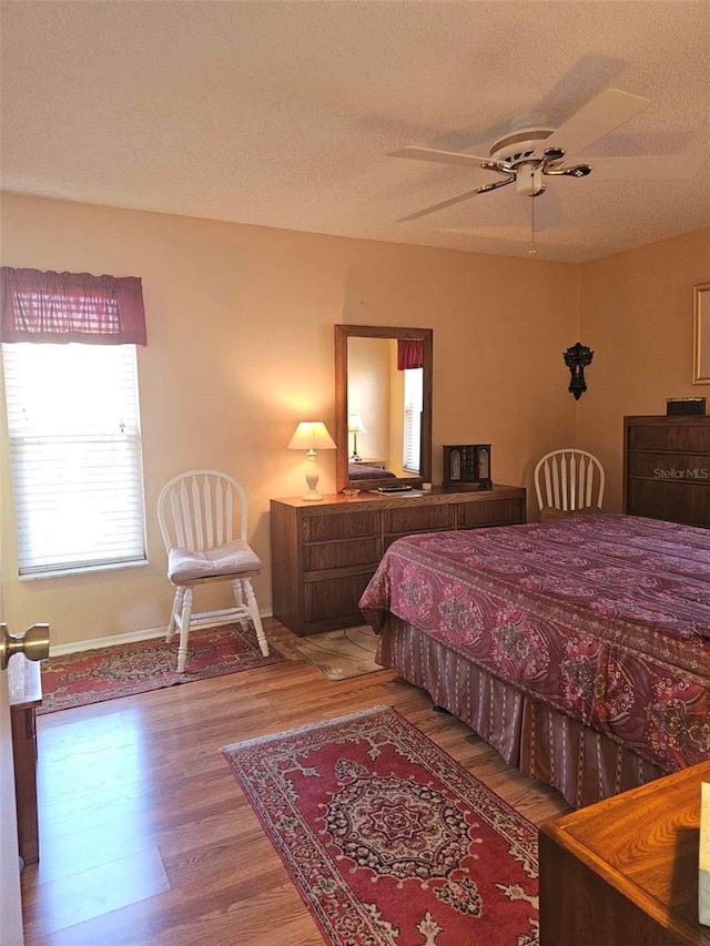 bedroom featuring a textured ceiling, hardwood / wood-style flooring, and ceiling fan