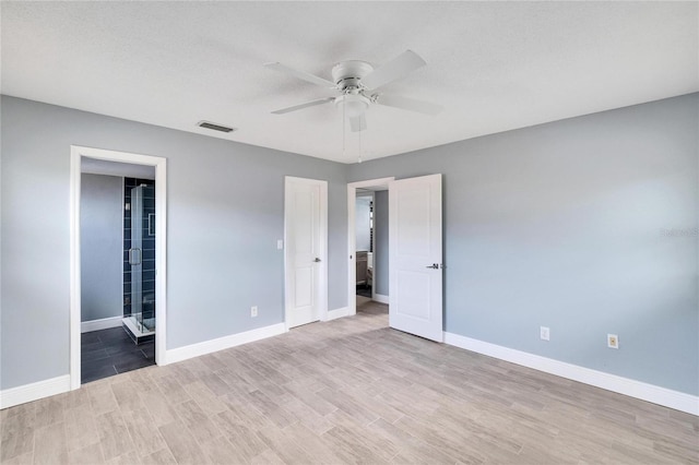 unfurnished bedroom with ceiling fan, light hardwood / wood-style floors, and connected bathroom