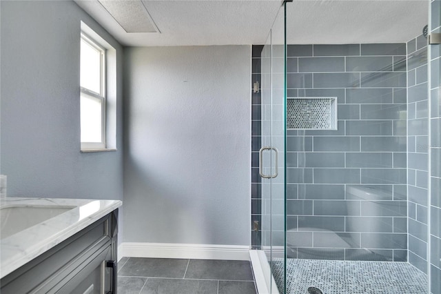 bathroom with tile patterned flooring, vanity, plenty of natural light, and a shower with shower door