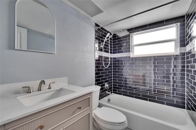 full bathroom featuring tiled shower / bath combo, toilet, and vanity