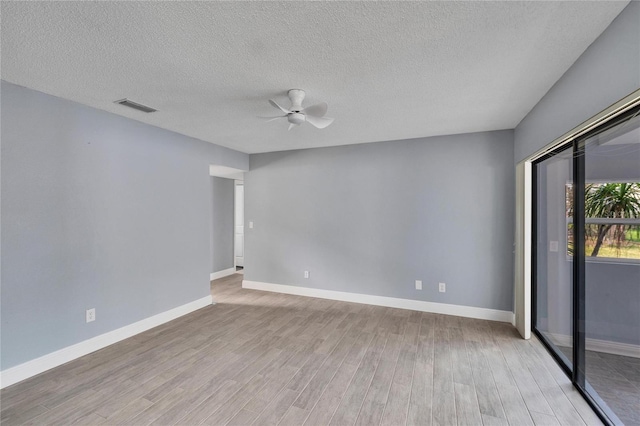 spare room with ceiling fan, light hardwood / wood-style flooring, and a textured ceiling