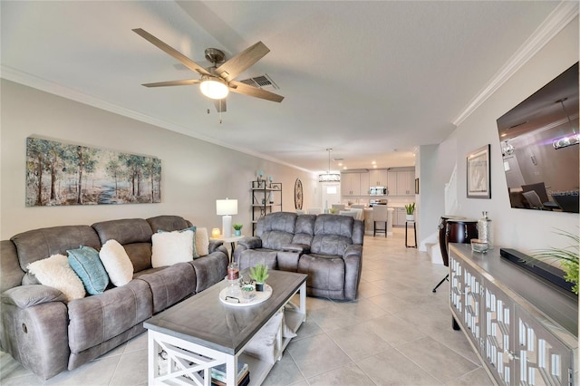 living room with ceiling fan, light tile patterned flooring, and ornamental molding